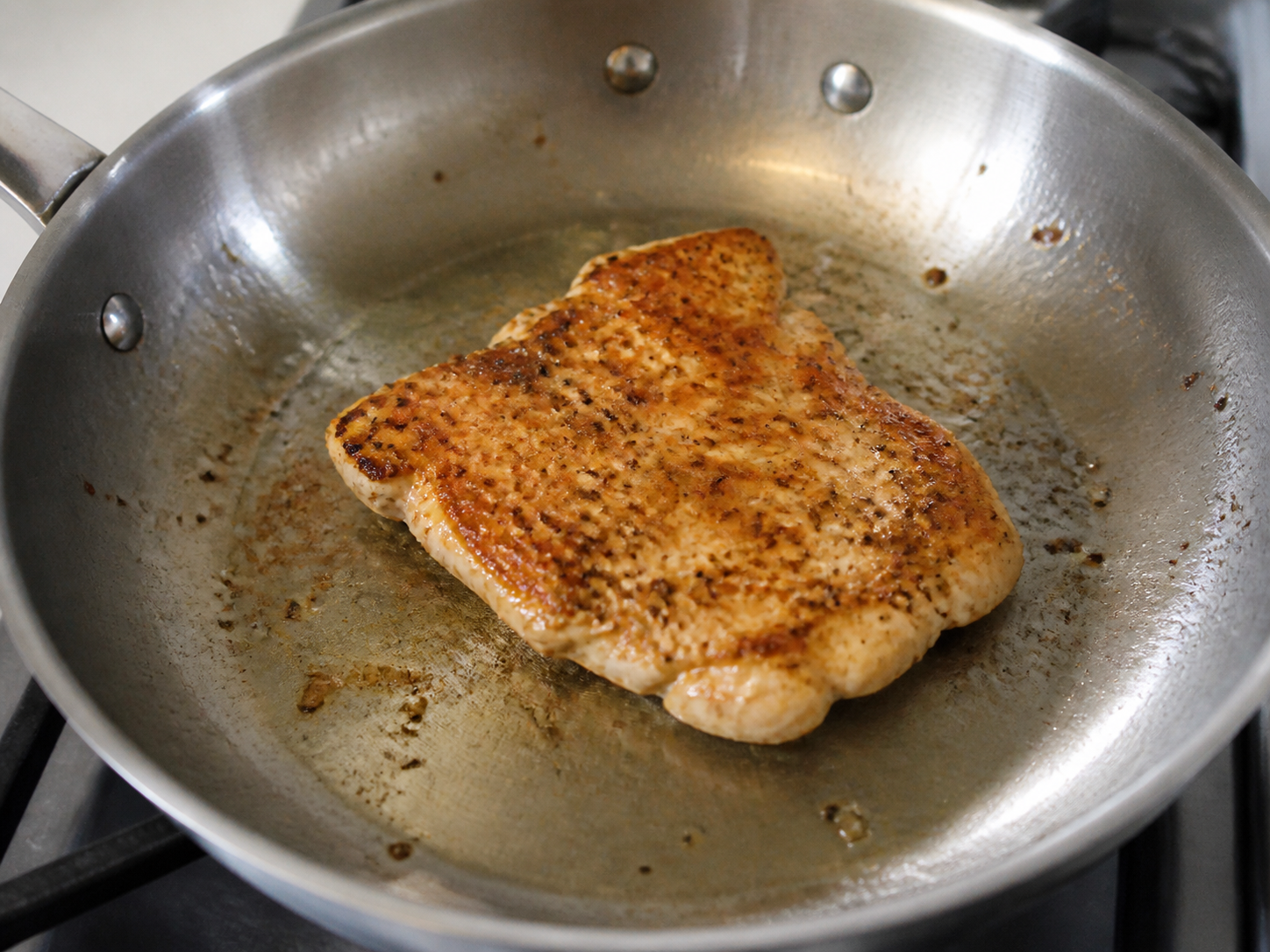 A chicken cutlet with an even golden-brown seared crust