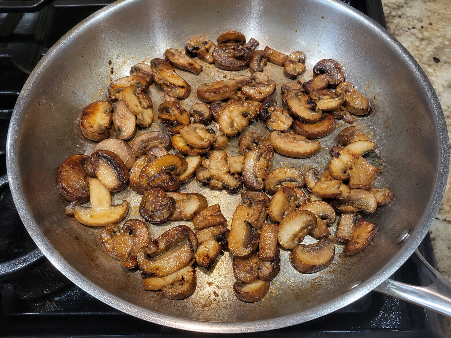 Mushrooms browning with a controlled sizzle at useful pan heat